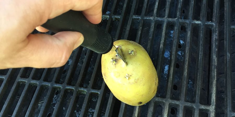 Gnid en kartoffel på grillristen inden grillning